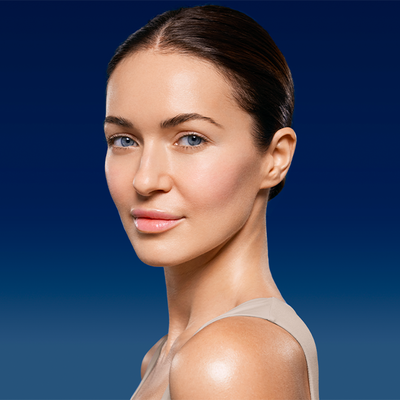 Young woman with luminous skin and dark hair slicked back against a navy background